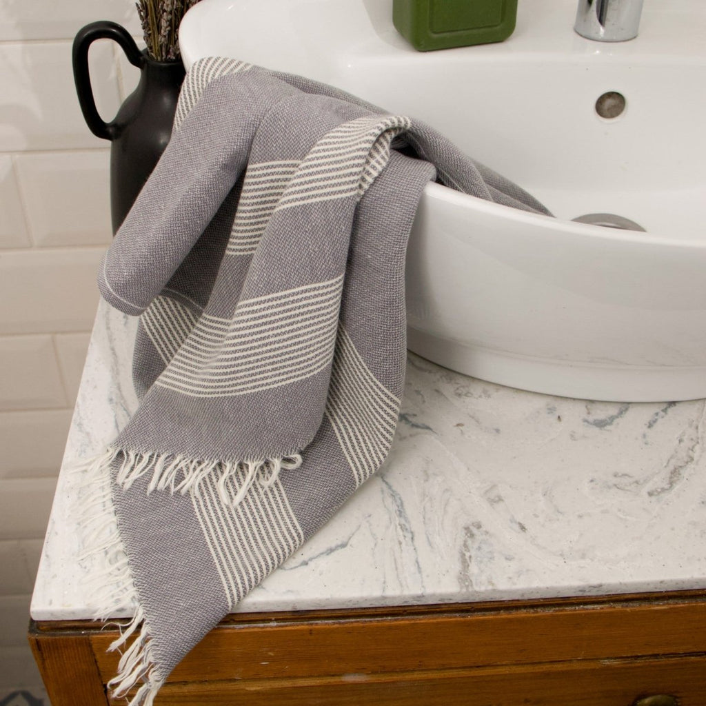 Anza Charcoal Grey Amber Turkish Hand Towel on bathroom sink          